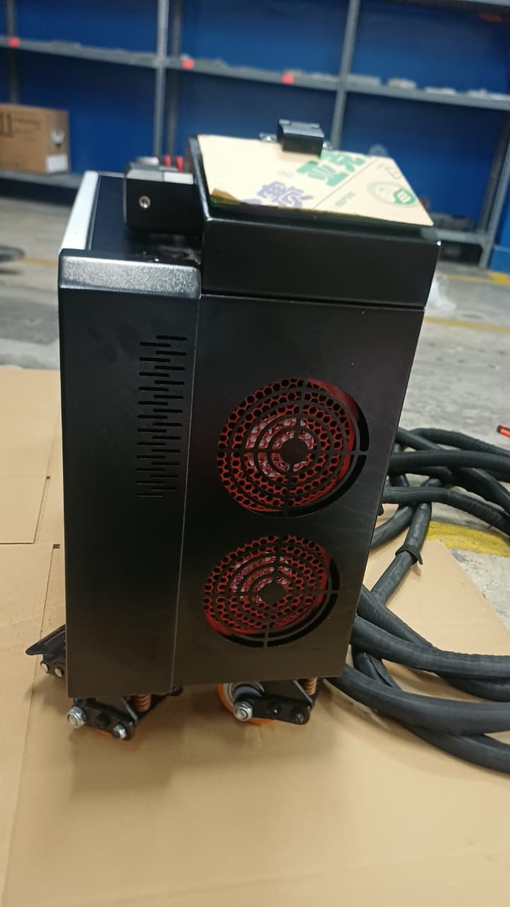 Vista lateral de la máquina de limpieza láser, con dos ventiladores de refrigeración y el cable de la pistola láser