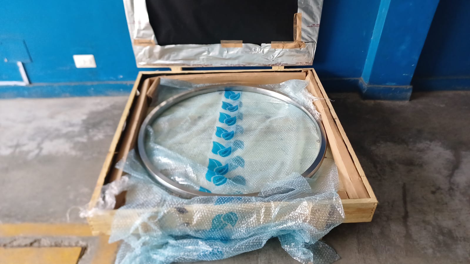 Empaque metálico RTJ dentro de un cajón de madera abierto, protegido con plástico de burbujas