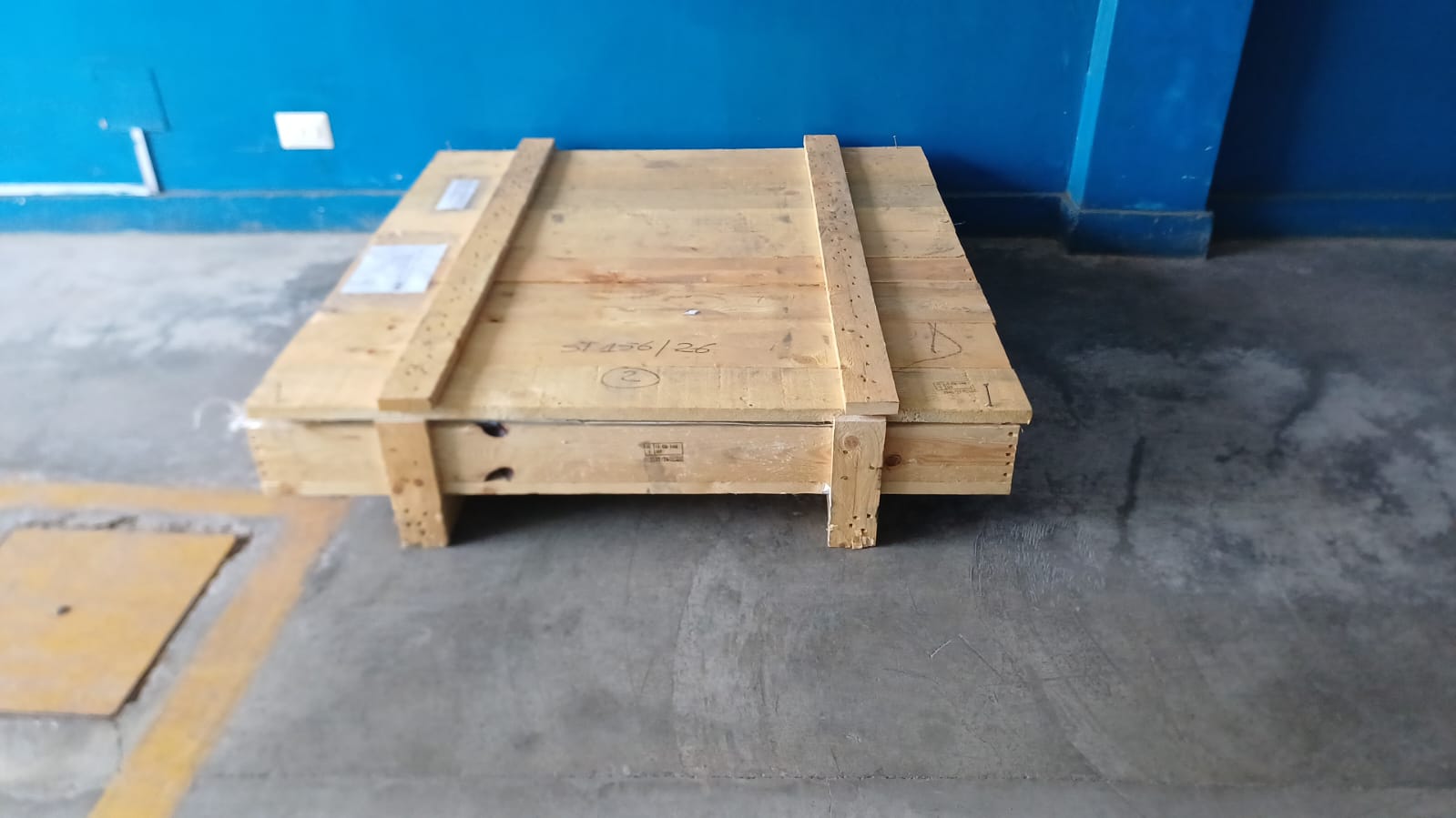 Cajón de madera cerrado del embalaje de los empaques, sobre el piso de un almacén