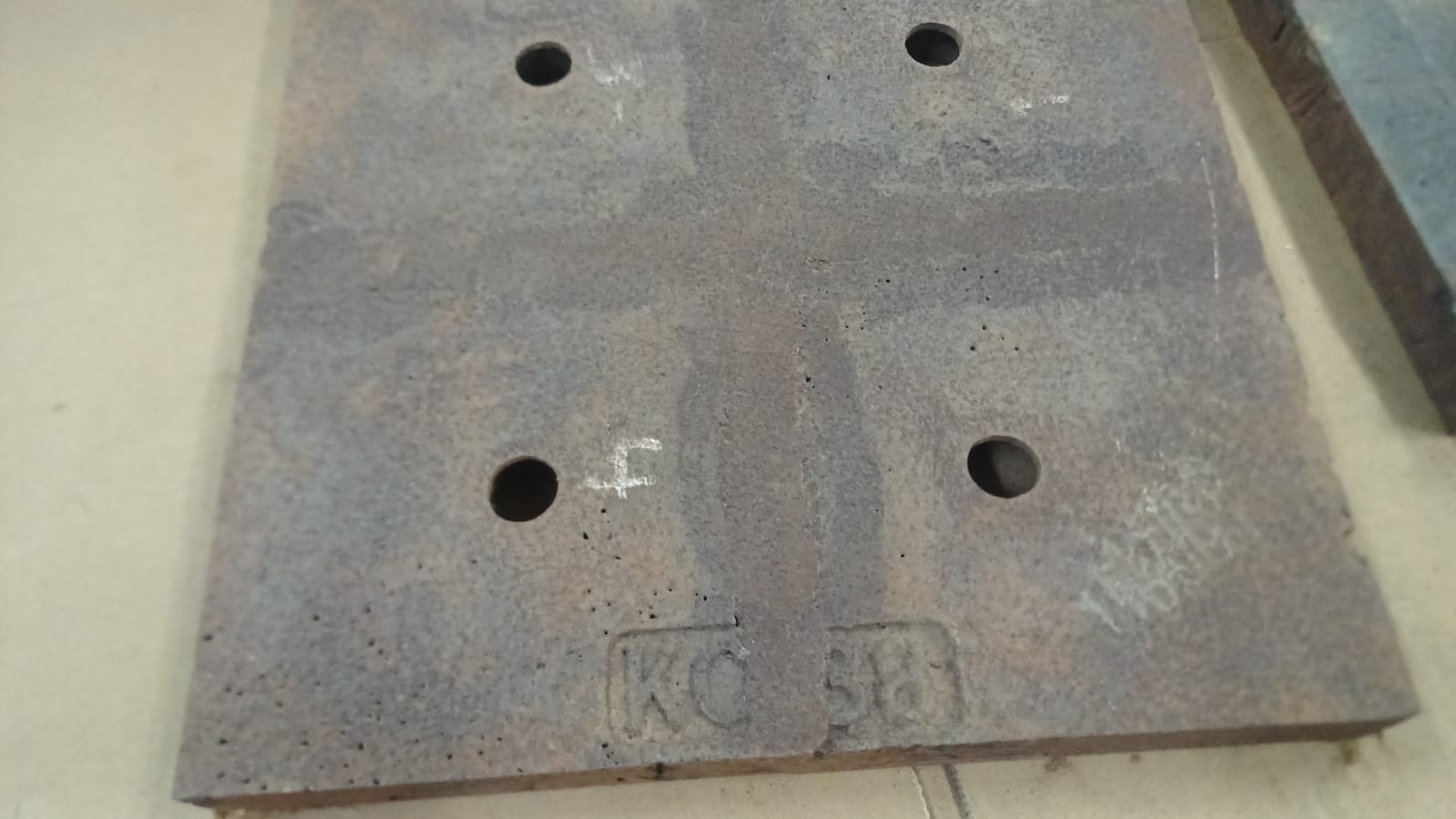 Placa Steplate de Kennametal con cuatro perforaciones de fijación, apoyada sobre cartón