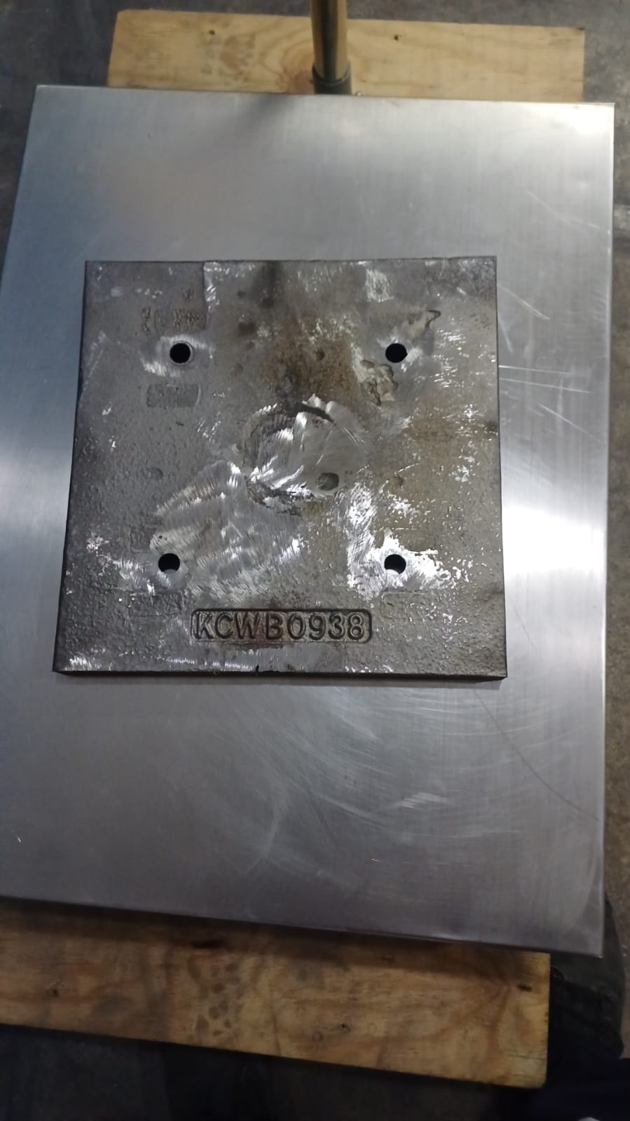 Placa Steplate de Kennametal con la marca KCWB0938, sobre una plancha de acero